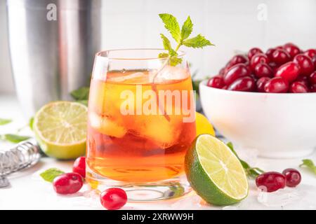 Kornelkirsche, Harthölzer essbare Beere Caipirinha, Limonade oder Sangria Getränk mit Eiswürfeln und Limettensaft, auf weißem Küchentisch Hintergrund Kopie sp Stockfoto