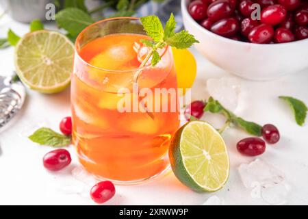 Kornelkirsche, Harthölzer essbare Beere Caipirinha, Limonade oder Sangria Getränk mit Eiswürfeln und Limettensaft, auf weißem Küchentisch Hintergrund Kopie sp Stockfoto