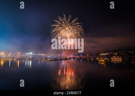 Langzeitaufnahme von farbenfrohen Feuerwerken über dem Meer für die lokalen Feste in Portonovo, Sanxenxo, Galicien. Stockfoto