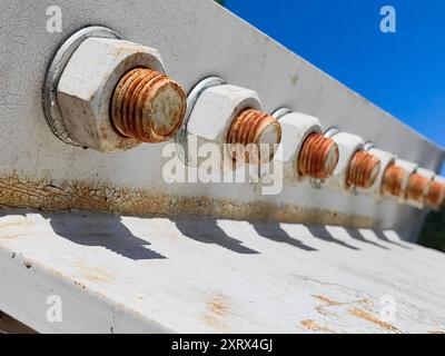 Rostige Schrauben, Teil der Metallbrückenkonstruktion. Licht und Schatten. Weiße Farbe. Nahaufnahme. Stockfoto
