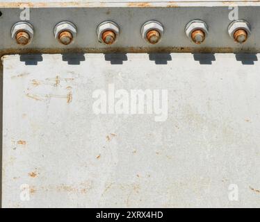 Rostige Schrauben auf White Metal Bridge Construction: Licht- und Schattenspiel. Stockfoto