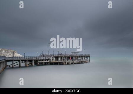 Der Pier in Swanage, Dorset, an der Südküste Englands. Der Tag ist bewölkt. Eine lange Verschlusszeit wurde verwendet, um das Wasser und die Wolken zu glätten Stockfoto