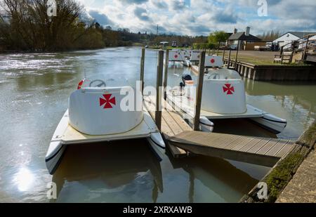 Das 1921 gegründete Radley Boathouse befindet sich an einem wunderschönen Teil der Themse in Oxfordshire und dient seit über einem Jahrhundert Radley College und lokalen Ruderfreunden. Hier sehen wir eine Reihe von Freizeitbooten, die früh an einem schönen Wintermorgen vor Anker liegen. Warum das maltesische Kreuz? Das ist eine lange Geschichte... Diese wurde ursprünglich vom College als Abzeichen für alle Sportarten um 1850 angenommen. Es wurde zum Symbol des Boat Clubs von der frühesten bekannten Besatzung und wurde wahrscheinlich zu Ehren von Sir George Bowyer, dem Besitzer von Radley Hall, adoptiert, von dem das Haus und das Gelände gemietet wurden, als es zum Zeitpunkt des Todes gehörte Stockfoto