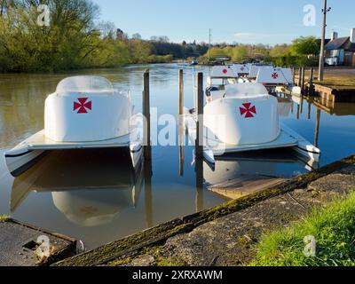 Das 1921 gegründete Radley Boathouse befindet sich an einem wunderschönen Teil der Themse in Oxfordshire und dient seit über einem Jahrhundert Radley College und lokalen Ruderfreunden. Hier sehen wir eine Reihe von Vergnügungsbooten, die früh an einem schönen Frühlingsmorgen vor Anker liegen. Warum das maltesische Kreuz? Das ist eine lange Geschichte... Diese wurde ursprünglich vom College als Abzeichen für alle Sportarten um 1850 angenommen. Es wurde zum Symbol des Boat Clubs von der frühesten bekannten Besatzung und wurde wahrscheinlich zu Ehren von Sir George Bowyer, dem Besitzer von Radley Hall, adoptiert, von dem das Haus und das Gelände gemietet wurden, als es zum Zeitpunkt des Todes gehörte Stockfoto