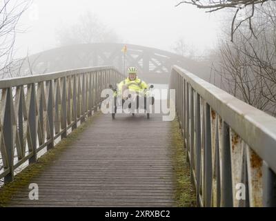 Ein landschaftlich reizvoller Teil der Themse, der in Kennington in den Hinksey Stream mündet. Dies ist Teil des Themsepfades und die Szene wird von zwei Brücken dominiert – einer verlassenen Eisenbahnbrücke, die viele Jahre ungenutzt war, in der Ferne; im Vordergrund eine Fußgängerbrücke über den Hinksey-Zufluss. Das Ergebnis ist eher abstrakt in der Komposition, besonders im Winternebel, mit einem liegenden Radfahrer, der die Fußgängerbrücke überquert. Stockfoto