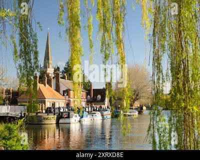 Blick unter einer Weide auf die Themse bei Abingdon an einem schönen Frühlingsmorgen. Wir befinden uns am Nordufer des Flusses und blicken flussabwärts in Richtung St Helen's Wharf - ein berühmter Schönheitsort am Fluss - und zur angelsächsischen Kirche St. Helens, nach der der Kai benannt ist. Stockfoto