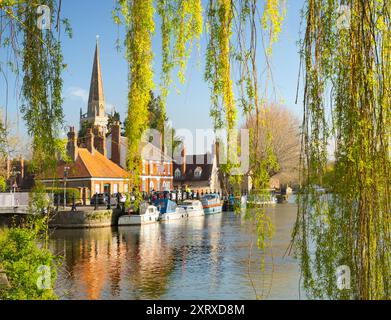 Blick unter einer Weide auf die Themse bei Abingdon an einem schönen Frühlingsmorgen. Wir befinden uns am Nordufer des Flusses und blicken flussabwärts in Richtung St Helen's Wharf - ein berühmter Schönheitsort am Fluss - und zur angelsächsischen Kirche St. Helens, nach der der Kai benannt ist. Stockfoto