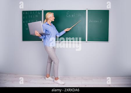 Foto einer charmanten Hochschullehrerin, die Vorlesungsstunde für Kinder im Klassenzimmer durchführt Stockfoto