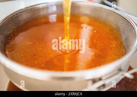 Viscouse Golden Bee Honig tropft und fließt in Einen Pool aus süßem köstlichem Honig Stockfoto