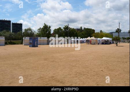 Viladecasn, SPANIEN - 12. AUGUST 2024: Festspielszene mit weißen Ständen für kulturelle Veranstaltungen unter teilweise bewölktem Himmel. Stockfoto