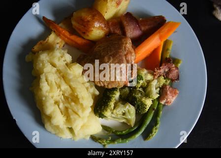 Die Bilder zeigen ungekochtes Gemüse und eine gekochte Hühnermahlzeit mit Gemüse und Soße. Bilder könnten verwendet werden, um 5 Tage Gemüseaufnahme hervorzuheben. Stockfoto