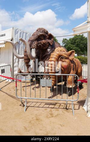 Viladecasn, SPANIEN - 12. AUGUST 2024: Lebensgroße Mammut-Modelle ziehen auf der Messe Sant Isidro vor dem Hintergrund weißer Zelte und teilweise Colozelte die Aufmerksamkeit auf sich Stockfoto