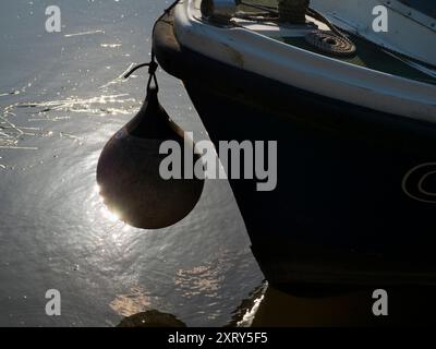 Vergnügungsboot und Boje an der Themse, Sonne reflektiert vom Wasser. Das 1849 erbaute, gut ausgestattete Ruderzentrum und Wassersportzentrum Radley Boathouse hat das Glück, an einem besonders schönen Abschnitt der Themse zu liegen. Aber hier ist die Frage: Wie heißt die Boje? Eine kleine Suche zeigt, dass es verschiedene Namen hat wie Stoßstange, Fender, Bootsball, Ankerboje und wahrscheinlich einige andere Namen, die ich verpasst habe. Aber interessiert uns das überhaupt? Stockfoto