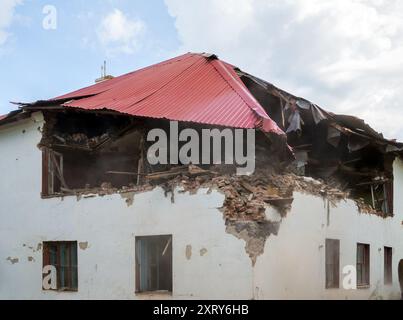 Eingestürztes Dach eines alten zweistöckigen Hauses Stockfoto