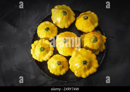 Herbstgemüse und Pilze auf schwarzem Hintergrund und eine Leinenserviette. Gelber Kürbis, Karotten, Tomaten und Gurken, Knoblauch, Zwiebeln und Zucchini Stockfoto