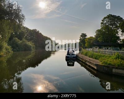 Blick auf die Themse vom Abingdon Lock. Abingdon-on-Thames behauptet, die älteste Stadt Englands zu sein. Und die Themse fließt durch ihr Herz. In dieser idyllischen Szene sehen wir von den Abingdon Locks aus einen recht schönen Blick auf den Fluss, gerade während die Sonne an einem schönen Sommermorgen aufgeht. So ruhig... Es gibt ein paar Aufnahmen, die es Wert sind, um 5:30 Uhr morgens aufzuwachen - aber dies ist sicher einer davon! Stockfoto