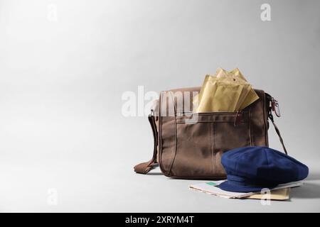 Braune Brieftasche, Briefumschläge, Zeitungen und Hut auf grauem Hintergrund. Leerzeichen für Text Stockfoto