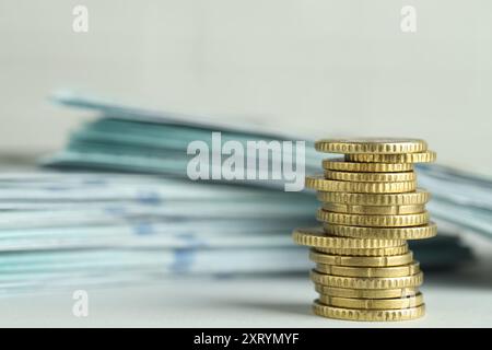 Stapel Euro-Münzen und -Banknoten auf hellgrauem Hintergrund Stockfoto