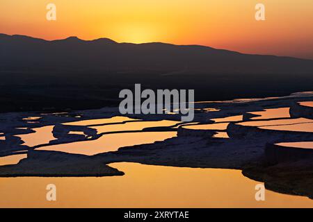 Natürliche Travertin-Pools und Terrassen bei Sonnenuntergang in Pamukkale, Türkei. Stockfoto