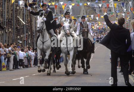 Braw Lads Meeting, das jährliche Reiten der Parish Boundaries - Common Ridings, das jedes Jahr im Juni stattfindet. Sie fahren in die Stadt, galoppieren die Scott Street - Galashiels - hinauf und werden am Ende des Tages von Stadtbewohnern und Besuchern gleichermaßen gefeiert. Galashiels, Selkirkshire, Schottland. Juni 1992 1990, UK HOMER SYKES Stockfoto