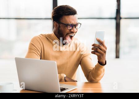 Porträt eines afroamerikanischen Mannes, der am Telefon schreit Stockfoto