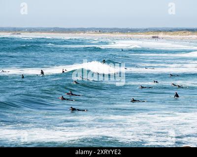 La Torche Beach, Frankreich; 9. August 2024: Surfer im Wasser in La Torche Beach, Französisch Bretagne, Frankreich Stockfoto