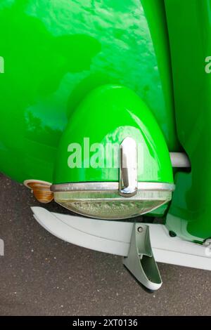 Klassische grüne Citroen 2CV mit Scheinwerferdetail vor einer Garage Paizay-le-SEC Frankreich Stockfoto