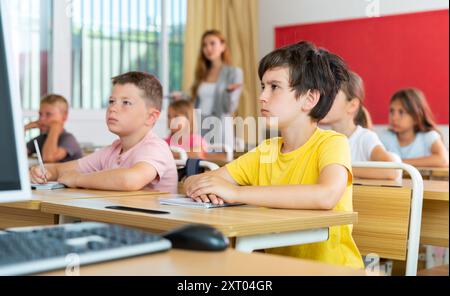 Fleißiger Jugendlicher, der mit Klassenkameraden in der Schule studiert Stockfoto