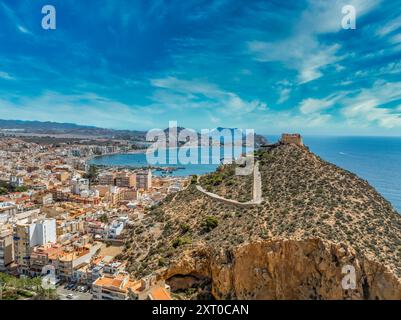 Aus der Vogelperspektive auf die Festung San Juan und den beliebten Strand in Aguilas Spanien, beliebtes mediterranes Touristenziel mit türkisfarbenem Wasser Stockfoto