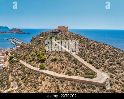 Aus der Vogelperspektive auf die Festung San Juan und den beliebten Strand in Aguilas Spanien, beliebtes mediterranes Touristenziel mit türkisfarbenem Wasser Stockfoto