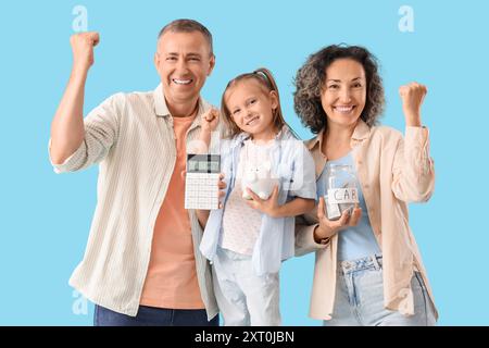 Glückliche Familie mit Schweinebank, Geldglas und Taschenrechner mit Ja-Geste auf blauem Hintergrund Stockfoto