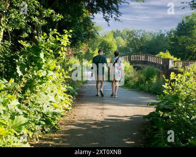 Diese wunderschöne alte Steinbrücke liegt am Iffley Lock an der Themse, flussabwärts von Oxford. Es ist früh an einem Sonntagmorgen, aber Sie können alle möglichen Menschen und Aktivitäten auf diesem Flussabschnitt sehen, zu jeder Jahreszeit, bei Regen oder Sonnenschein. Einschließlich dieses romantischen Paares... Stockfoto