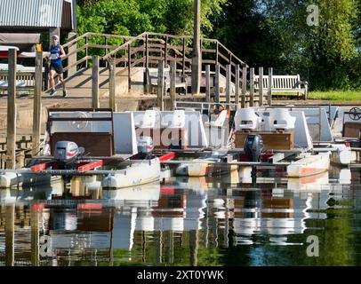 Das 1921 gegründete Radley Boathouse befindet sich an einem wunderschönen Teil der Themse in Oxfordshire und dient seit über einem Jahrhundert Radley College und lokalen Ruderfreunden. Hier sehen wir eine Reihe von Vergnügungs-Katamaranen, die an seinem Steg vertäut sind, während die Sonne aufgeht. Stockfoto