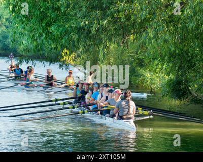 Ruderteams auf der Themse bei Iffley Lock und flussabwärts von Oxford. Es ist früh an einem Sonntagmorgen, aber man kann auf diesem Flussabschnitt zu jeder Jahreszeit, bei Regen oder Sonnenschein, alle Arten von Rudern sehen. Engagierte Seelen. Stockfoto