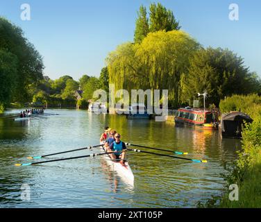 Ruderteams auf der Themse bei Iffley Lock und flussabwärts von Oxford. Es ist früh an einem Sonntagmorgen, aber man kann auf diesem Flussabschnitt zu jeder Jahreszeit, bei Regen oder Sonnenschein, alle Arten von Rudern sehen. Engagierte Seelen. Stockfoto