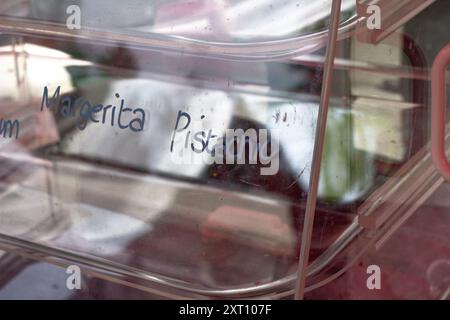 Zitrone, Brombeere, Bubblegum handgeschriebene Typografie verschiedener Macaron-Aromen auf Glas mit Reflexion von lokalen Bäckerverkäufern am Trout Lake B Stockfoto