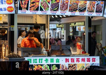 Suzhou, China - 11. Juni 2024 : Straßenhändler in Suzhou, China, mit verschiedenen Grillspießen. Stockfoto