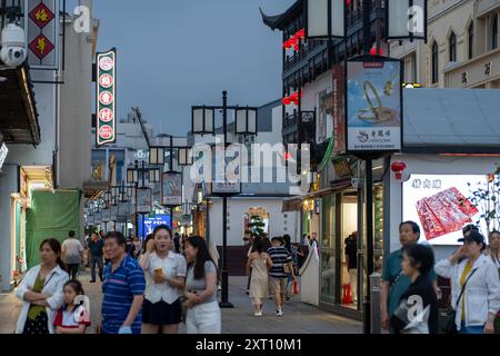 Suzhou, China - 11. Juni 2024 : Eine geschäftige Straße in Suzhou, China, mit traditioneller Architektur, Geschäften und Fußgängern. Stockfoto