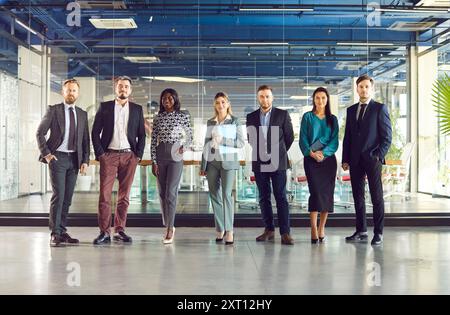 Gruppenporträt selbstbewusst lächelnder multirassischer Geschäftsleute, die im Business Center nebeneinander stehen. Stockfoto