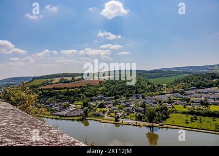 Panoramablick auf den Stadtrand von Givet von der Festung Charlemont, dem Fluss Maas und Land auf grünem Feld, Bäumen auf Hügel und Horizont im Hintergrund, su Stockfoto
