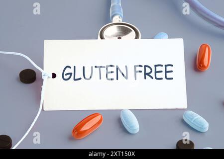 Glutenfreies Backkonzept. GLUTENFREIES Wort auf einer weißen Karte auf grauem Hintergrund. Konzeptfoto Stockfoto