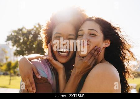 Glückliche Frauen, die den Sonnenschein im Freien genießen und die Essenz der besten Freunde festhalten. Freundinnen, die zusammen albern sind. Stockfoto