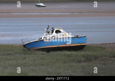 Glassdon Dock, Lancaster, Cumbria, England Großbritannien 31. Juli 2024 Ein Boot liegt am Ufer vor dem Glassdon Dock Glasson Dock, auch bekannt als Glasson, ist ein Dorf im Süden von Lancaster an der Mündung des Flusses Lune. Sie wird noch heute als Hafen und Touristenort genutzt, da sie einen Teil der alten Eisenbahnstrecke als Teil einer Touristenroute nutzt. Das Gleisbett der stillgelegten Eisenbahnstrecke ist ein Park und Radweg, der Lancashire Coastal Way genannt wird. Die Gegend liegt in der Nähe von Morecambe Bay. Der Hafen ist immer noch für den Transport von Fracht in Betrieb. Touristen und Freizeitboote nutzen auch den Hafen, an dem die Docks angeschlossen sind Stockfoto