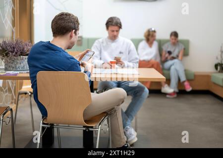 Unterschiedliche Situationen in den verschiedenen huisartsenpraktijk Eine Gruppe von Menschen, die in einem Wartezimmer sitzen, einige konzentrierten sich auf das Ausfüllen von Formularen, während andere sich mit diesen beschäftigen Stockfoto