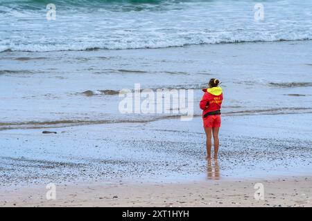 Eine RNLI-Rettungsschwimmerin im Dienst am Fistral Beach in Newquay in Cornwall in Großbritannien. Stockfoto