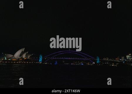 Sydneys Wahrzeichen, das Opernhaus und die Harbour Bridge, beleuchtet mit farbigen lazar-Lichtern, die am jährlichen Vivid Sydney Festival 2024 in New teilnehmen Stockfoto