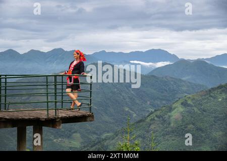 Red Dao Frau besucht einen Aussichtspunkt über die Berge im Hoang Su Phi Bezirk der Provinz Ha Giang, Nordvietnam Stockfoto