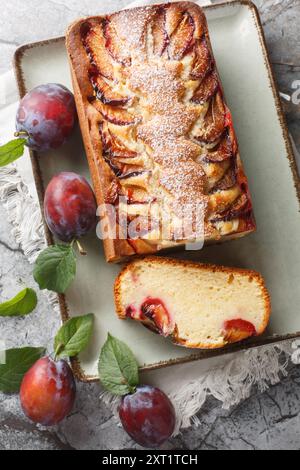 Leckerer Joghurt-Pflaumenkuchen aus Joghurt und Olivenöl ist leicht, feucht und köstlich zum Brunch und Nachtisch aus nächster Nähe auf dem Teller auf dem Tisch. Vertikal Stockfoto