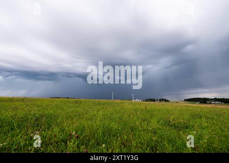 Dunkle Gewitterwolken ziehen über eine Wiese auf. Fluorn-Winzeln Baden-Württemberg Deutschland *** Dunkle Sturmwolken ziehen über eine Wiese in Fluorn Winzeln Baden-Württemberg Deutschland Stockfoto