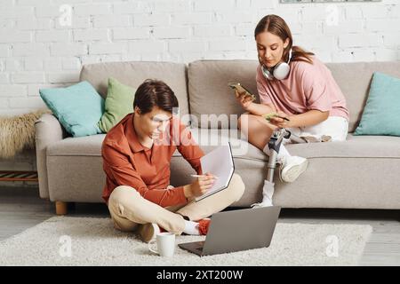 Frau mit Beinprothesen auf der Couch, während ihr Freund in der Nähe arbeitet. Stockfoto